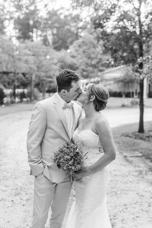 Black and white wedding photos show couple sharing tender moments in an outdoor garden setting.