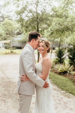 Newlywed couple shares joyful embraces in a lush garden setting.