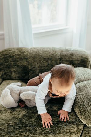 A sequence of photos showing a baby crawling on a textured green couch with a white pillow nearby.