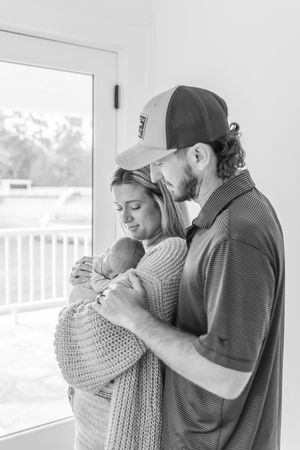 A tender embrace captured in black and white photography with soft natural lighting.