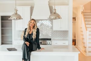 Modern white kitchen interior with pendant lights and herringbone backsplash featuring elegant design elements.
