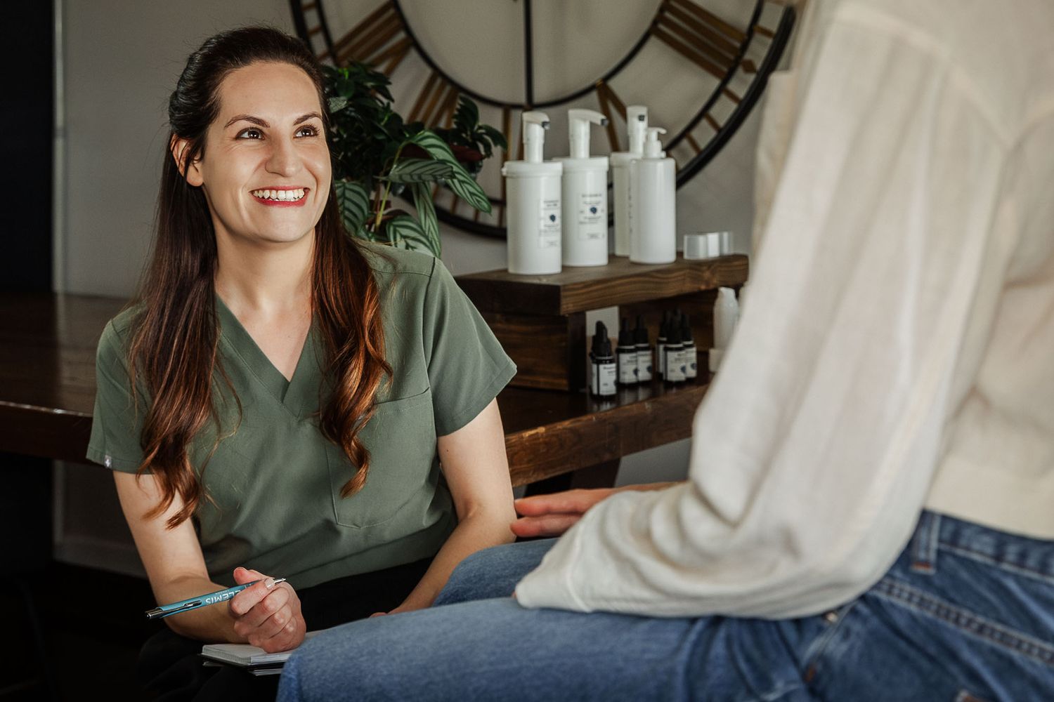 Bristol branding photography. A skin therapist looks natural and relaxed smiling as she chats to a client in her Clifton clinic.