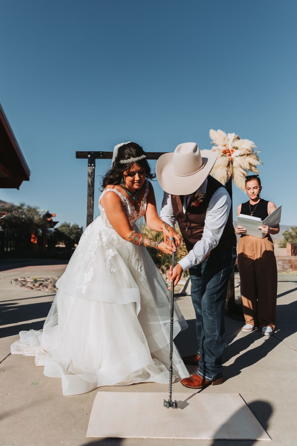 A couple participates in a unique golf-themed wedding ceremony activity outdoors.