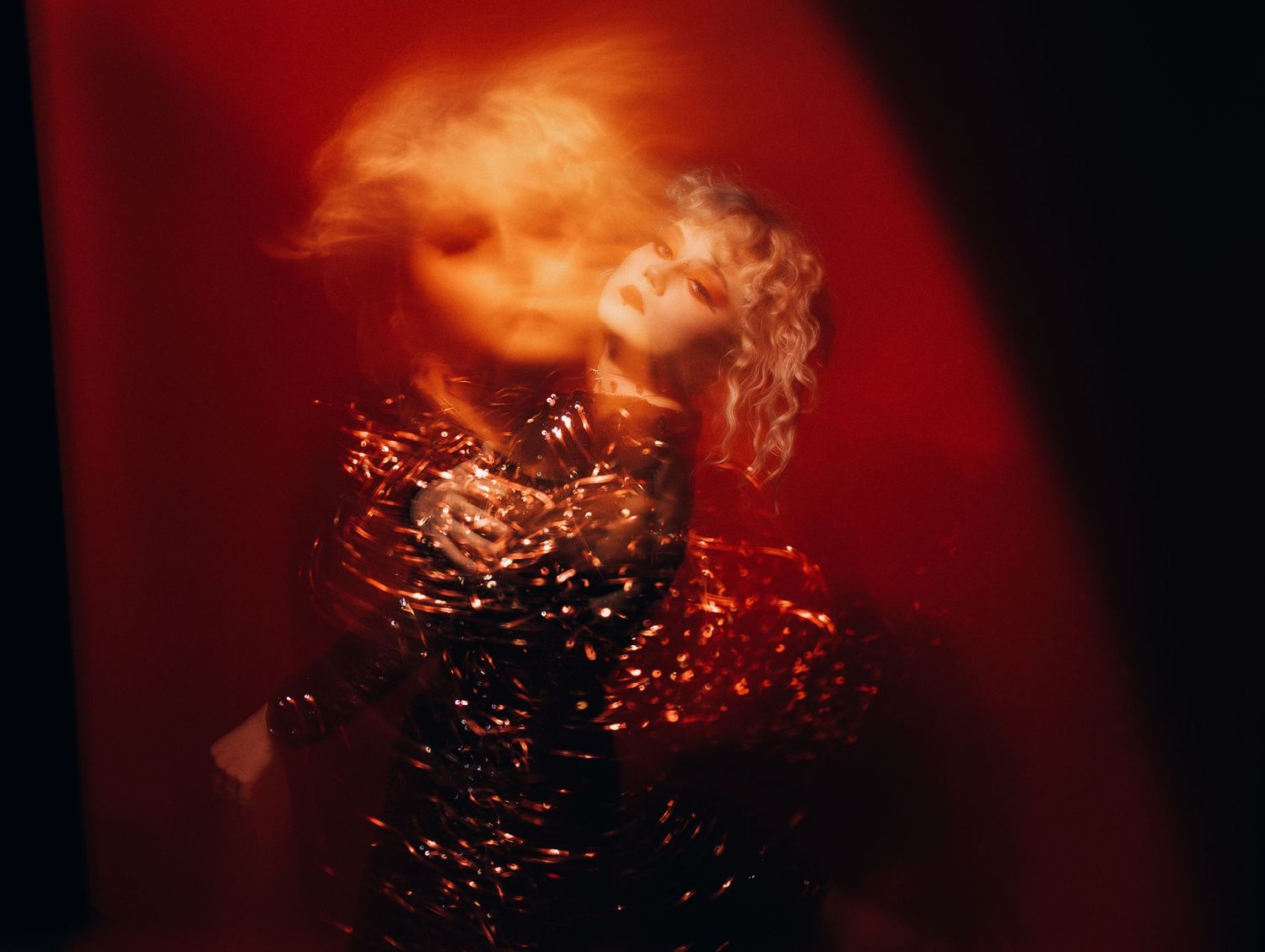 blond girl in a red photo studio in a shiny dress. soulful photo session in Vilnius