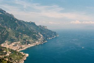 Aerial view of the stunning Amalfi Coast, Italy, with turquoise Mediterranean Sea, cliffside villages, and lush green mountains. Italy film