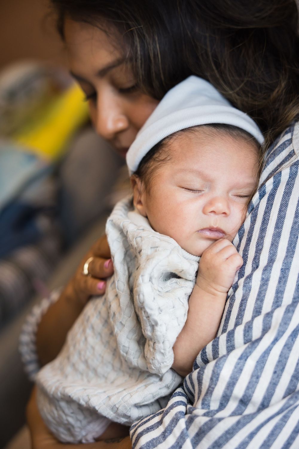 A sleeping baby rests peacefully against someone wearing a striped shirt in this tender portrait sequence.