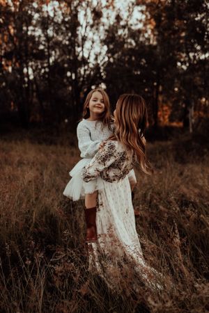 A joyful autumn moment between parent and child in a field of tall grass.