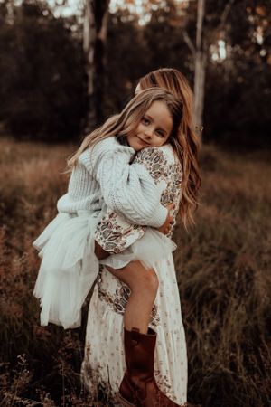 A tender moment captured between parent and child in a rustic outdoor setting.