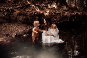 Dreamy forest scene with reflective water and warm brown tones in ethereal lighting.