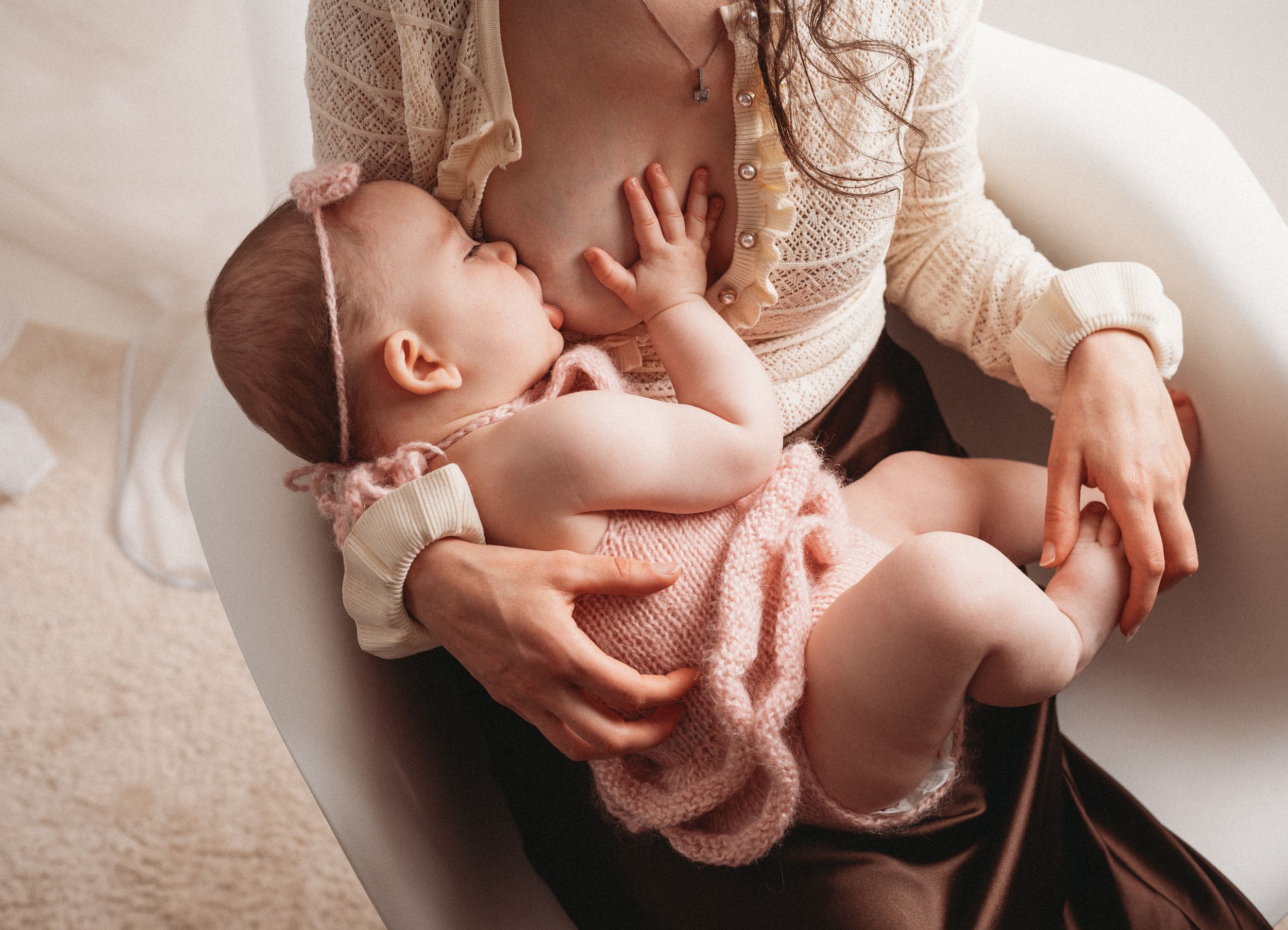 A series of tender newborn photography shots showing gentle hands cradling a sleeping baby in soft beige tones.