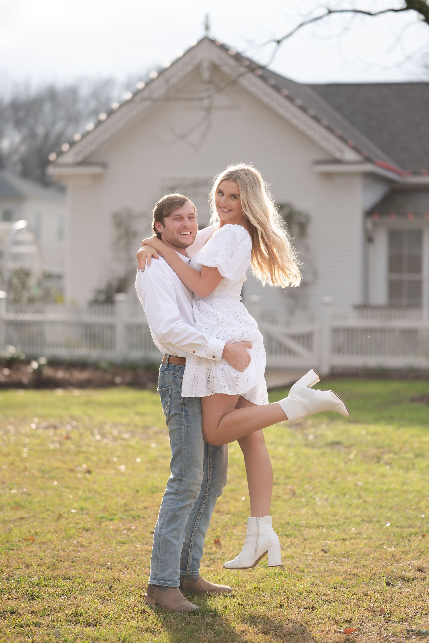 A playful scene unfolds on a grassy lawn with a white house in the background.