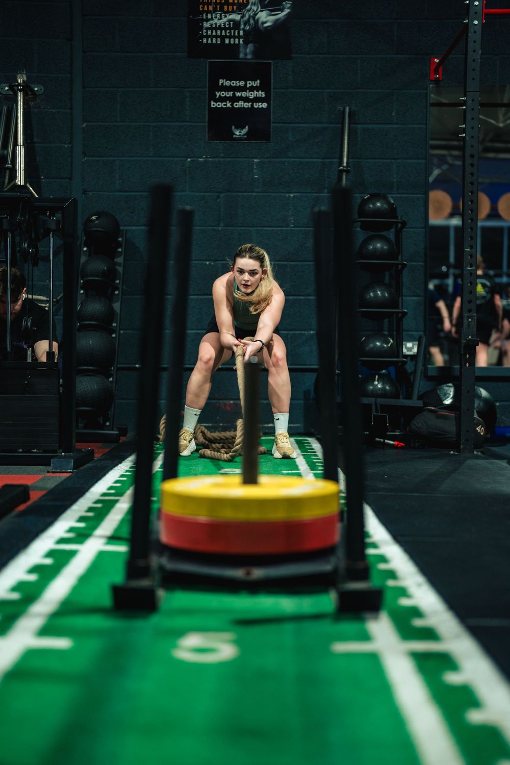 Athlete pushing a weighted sled on indoor turf at Freedom Gym in Tortworth.