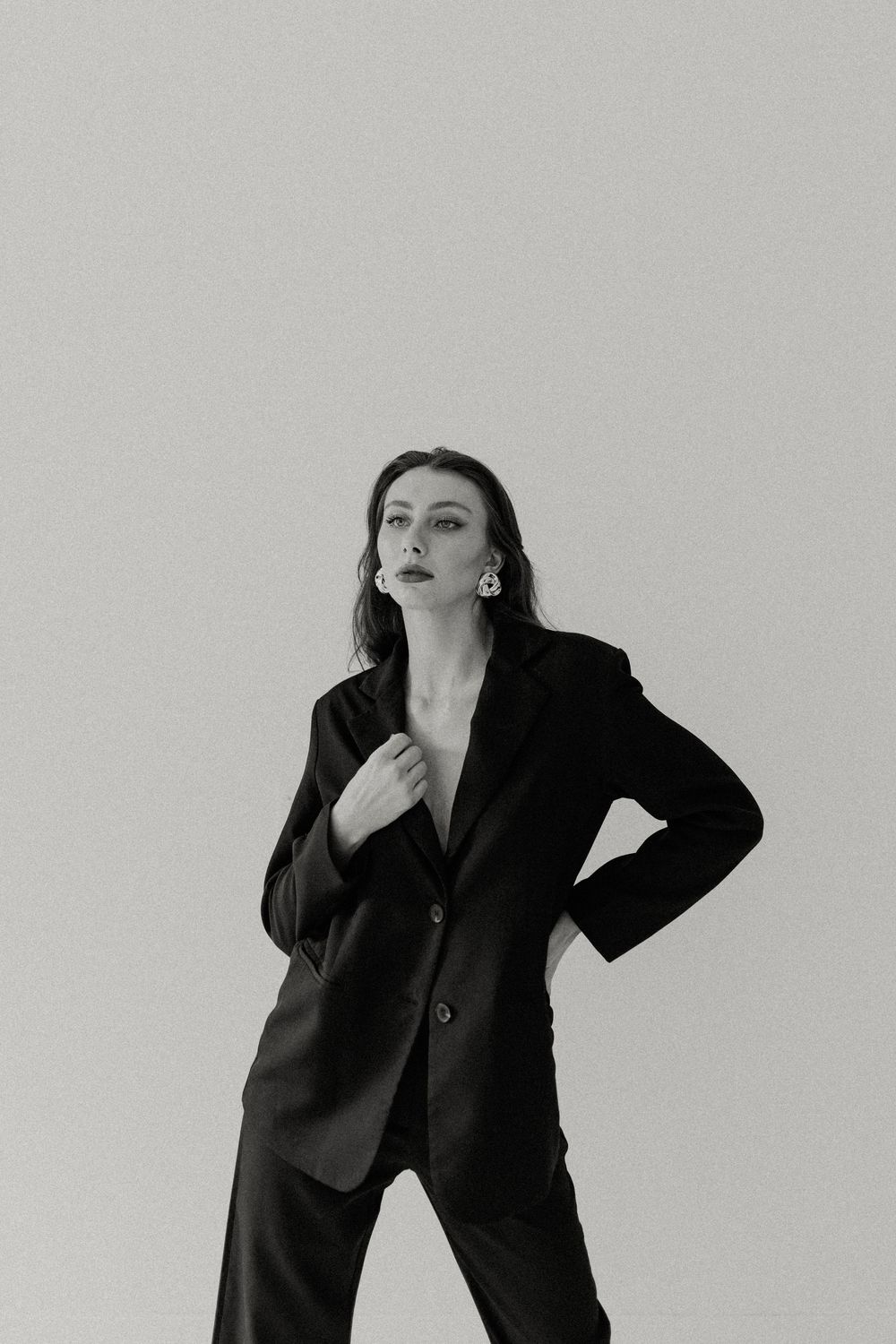black and white editorial pose of a woman in a black blazer and pantsuit