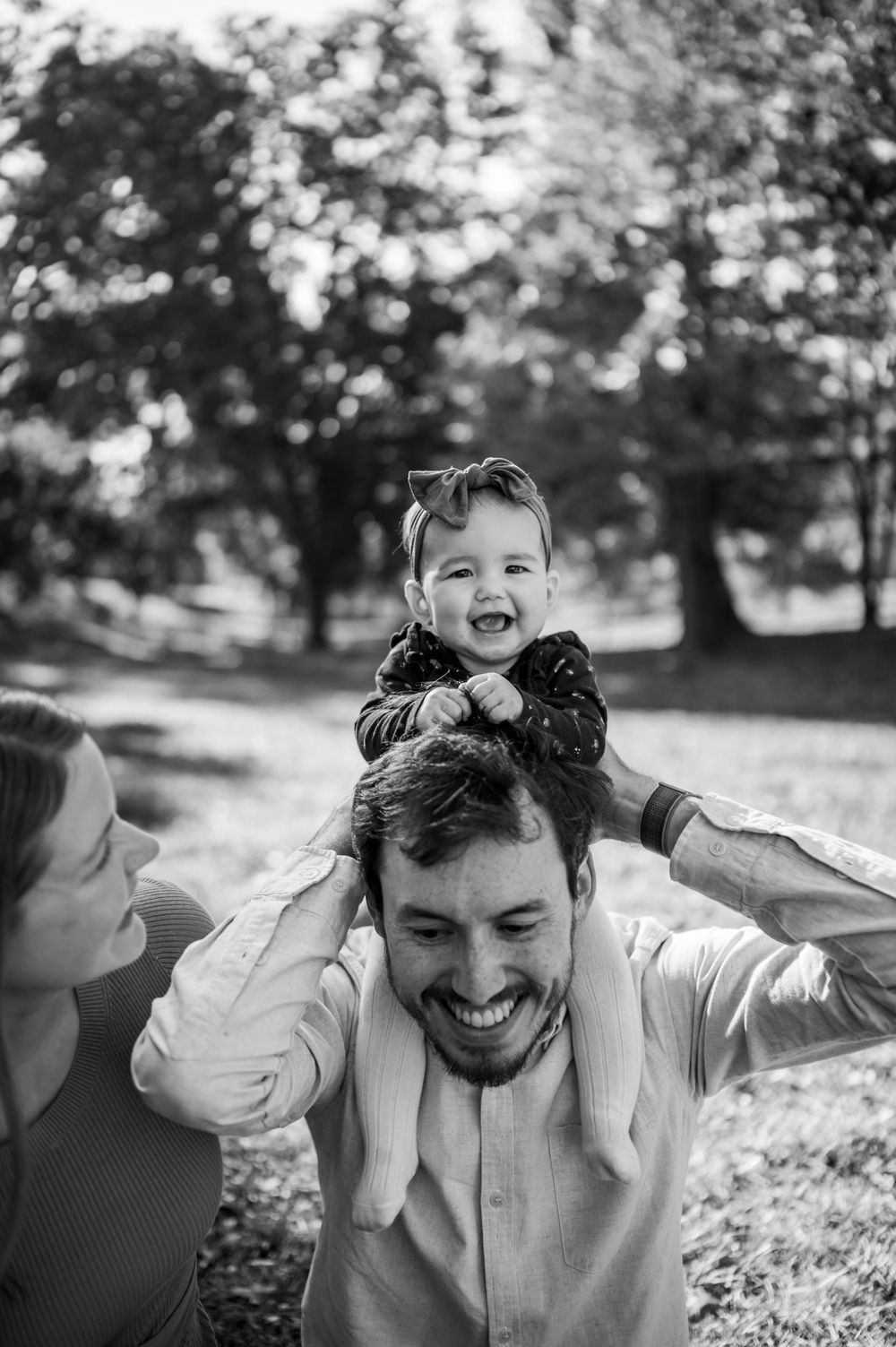 A joyful black and white portrait of a family playing outdoors.