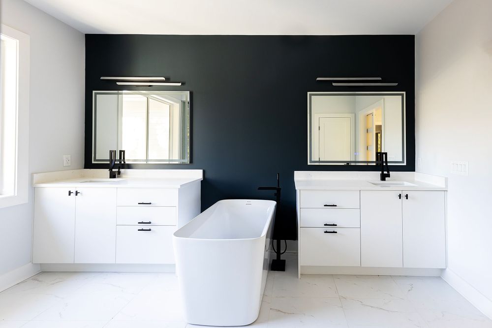 Sleek bathroom with dual vanities, freestanding tub, and dramatic black accent wall.