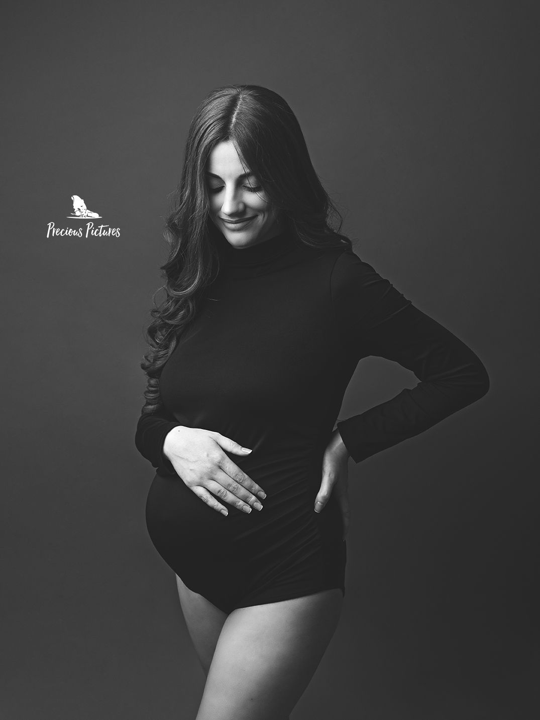 Classic black and white maternity photography in Malta featuring a smiling expectant mother in a chic black bodysuit Precious Pictures Rabat
