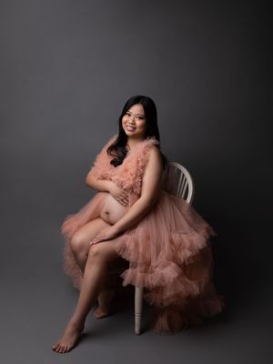 Beautiful maternity session in a peach tulle designer gown, seated studio portrait by Precious Pictures photography, Malta