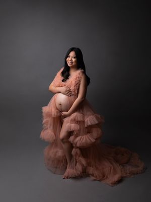 Glamorous studio maternity portrait in a peach ruffled tulle gown, professional pregnancy photography by Precious Pictures, Malta.