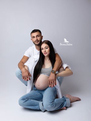 Timeless studio maternity portrait of a couple sitting in casual attire, bespoke pregnancy photography by Precious Pictures, Malta