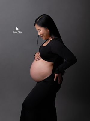 Elegant profile maternity portrait in a black open-belly gown, boutique studio photography by Precious Pictures, Rabat, Malta