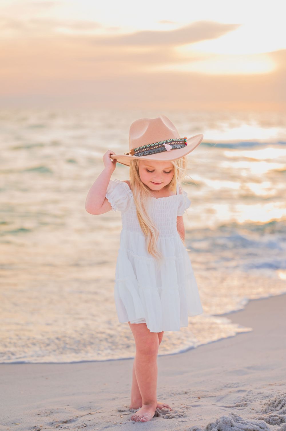 Little girl playing in the water on Panama City Beach during sunset