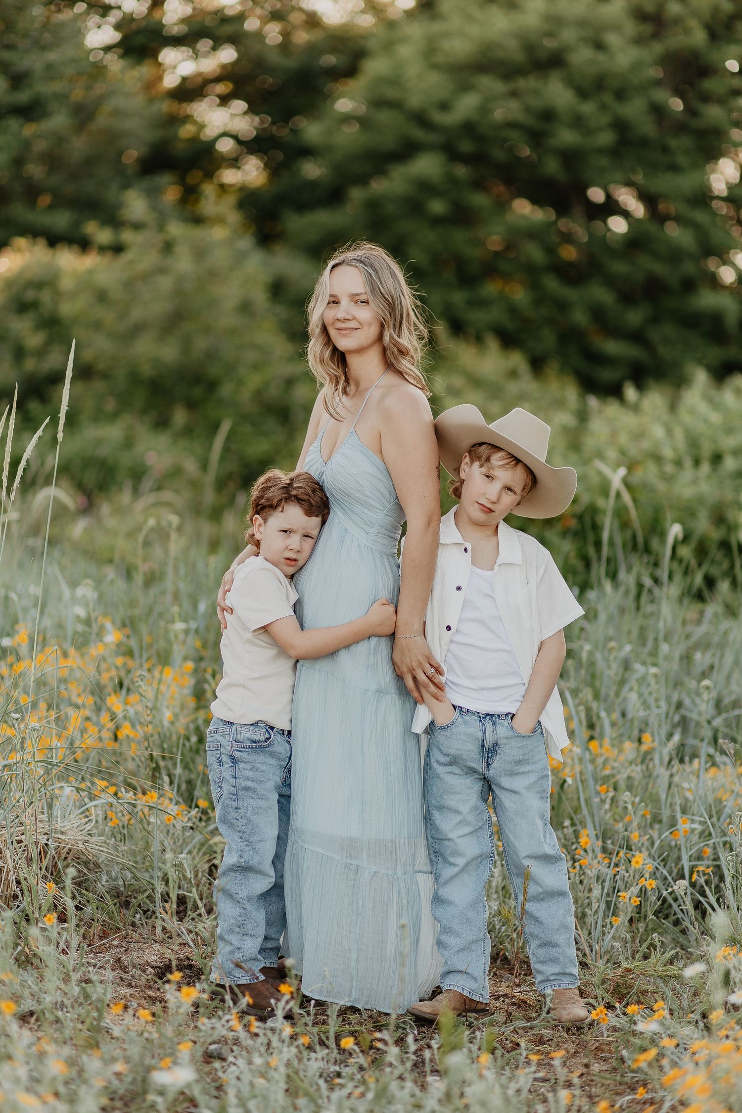 Family portrait in wildflower meadow with yellow blooms and green foliage.