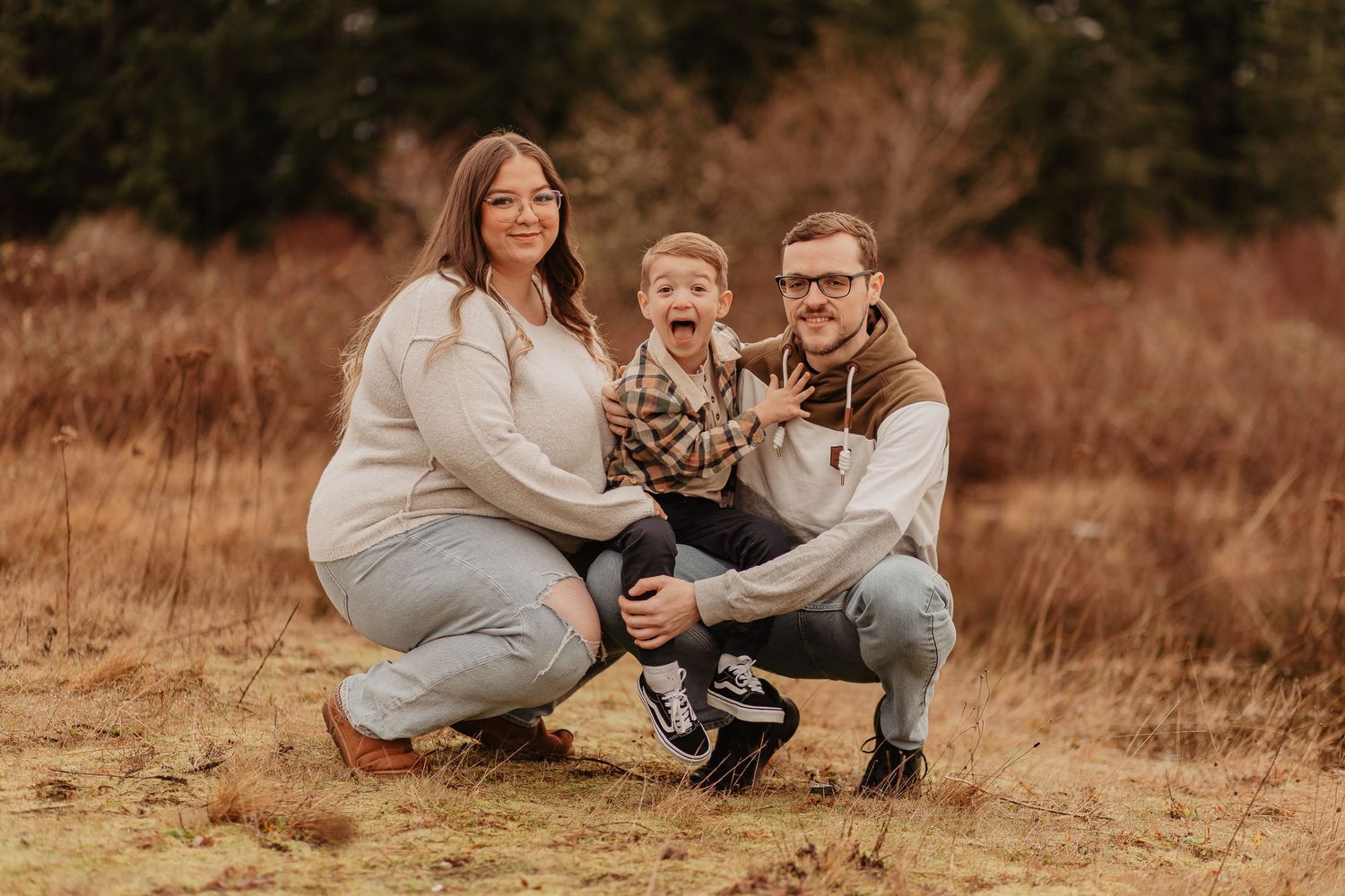 Family relaxes together on ground during an outdoor autumn photo session.