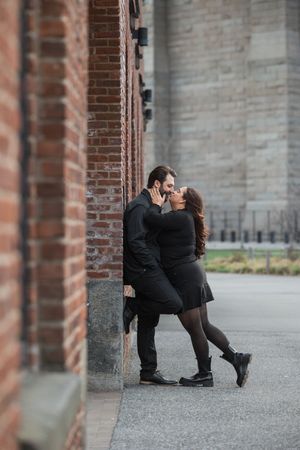 Playful couple dancing and embracing beneath architectural arches.