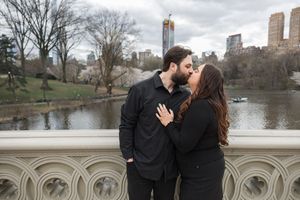 A romantic sequence captured on a bridge overlooking a scenic lake in an urban park.