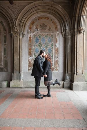 A romantic photo sequence under ornate stone archways with decorative details and tile flooring.