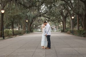 A romantic photo sequence along a tree-lined path with hanging lanterns at dusk.