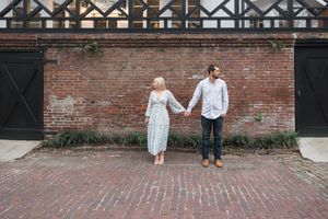 A series of photos showing a couple walking along a brick wall with architectural details.