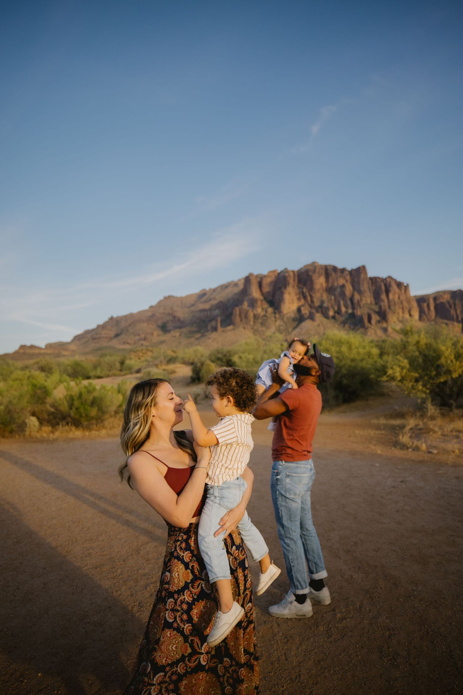 Family of four enjoying golden hour in the Arizona desert with Superstition Mountains backdrop.