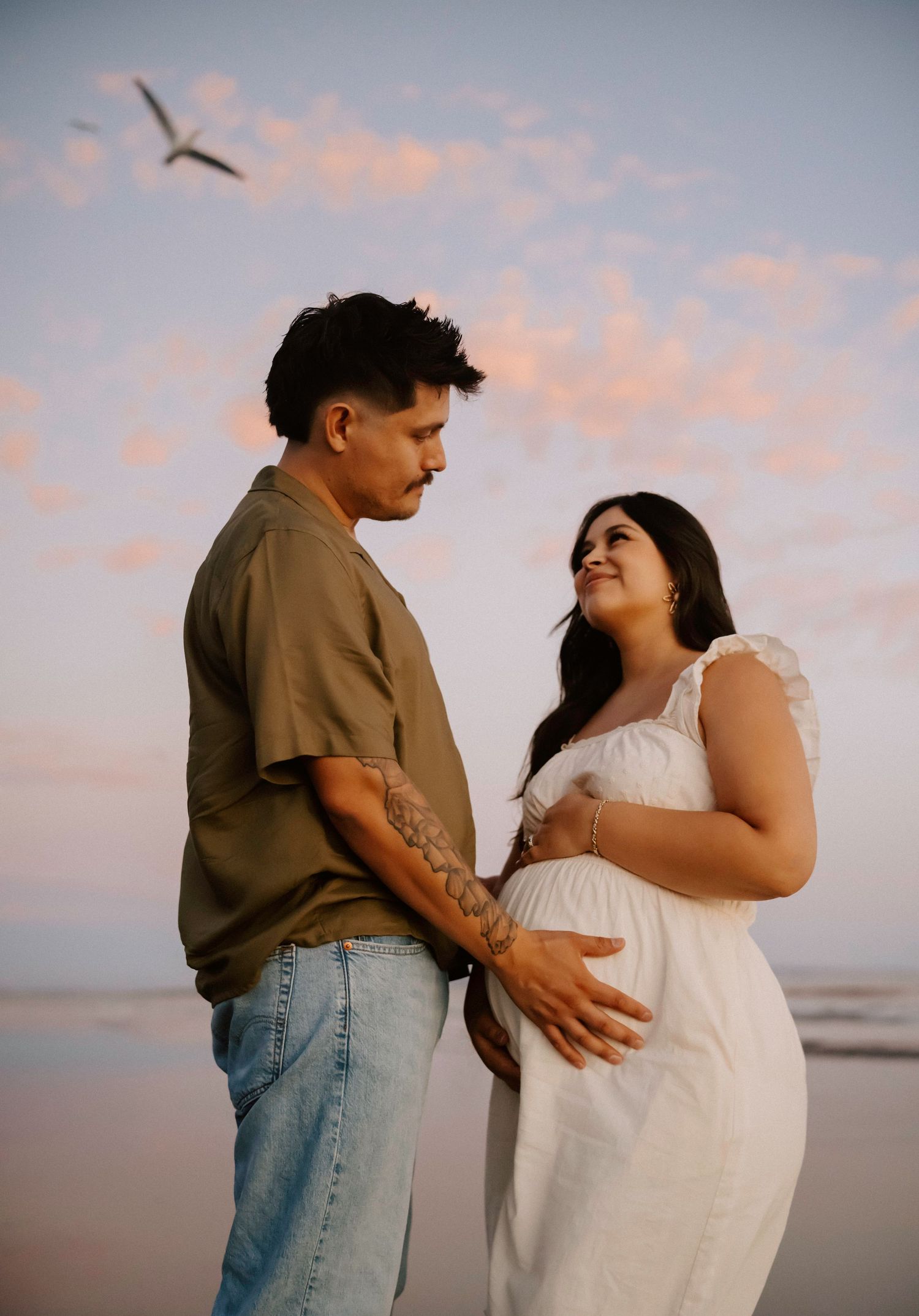 Intimate maternity photos captured at sunset on the beach.