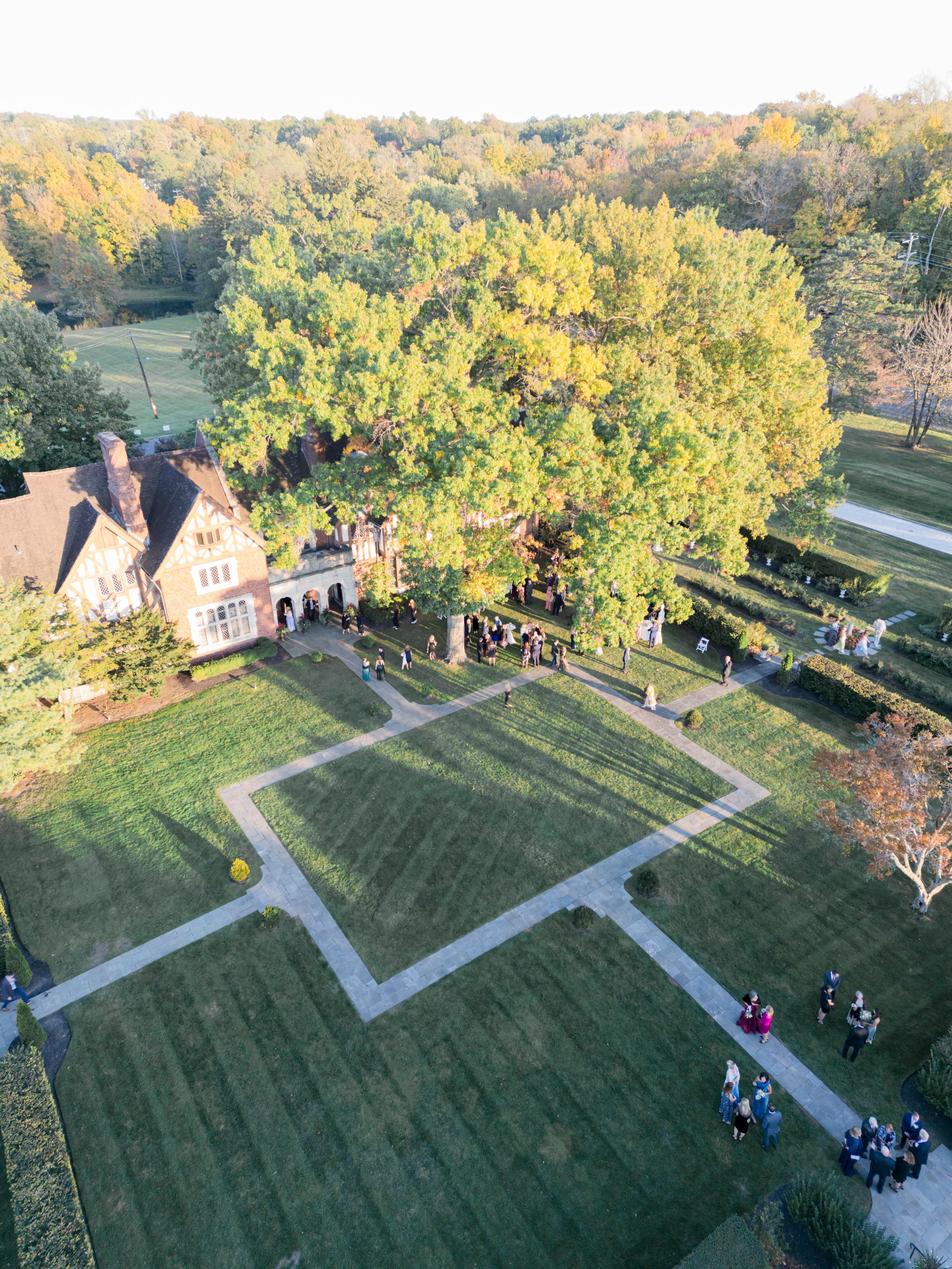 Aerial view of manicured garden paths and historic building during autumn season.