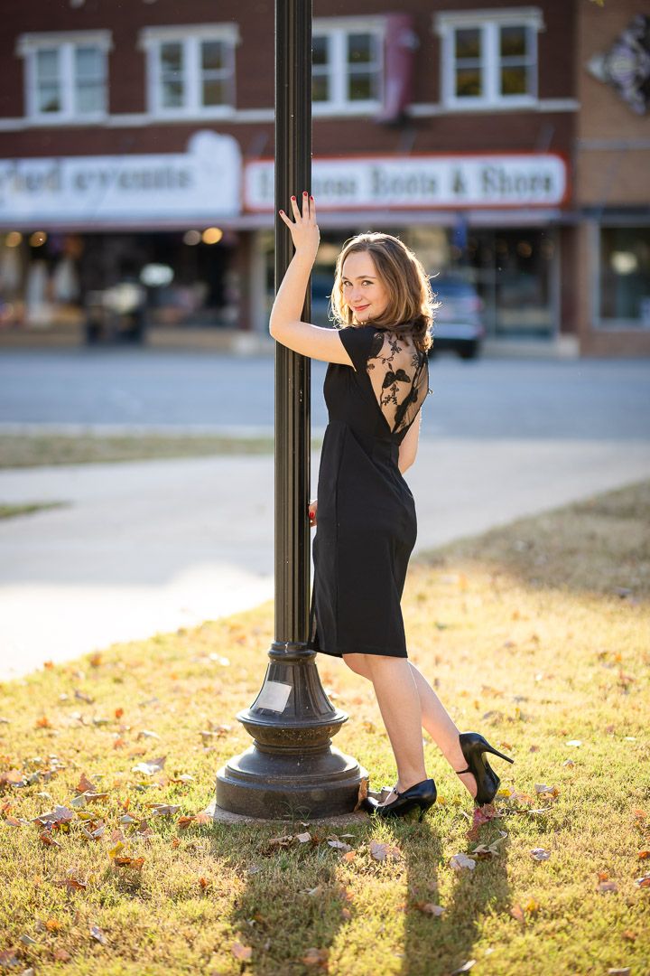 High school senior girl posing by a lamppost during a downtown senior session in Harrison, Arkansas