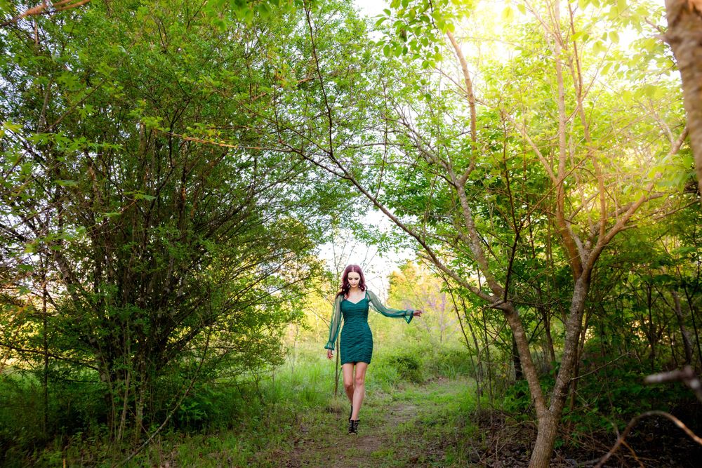 High school senior girl walking a wooded path during a senior session in Mountain Home, Arkansas