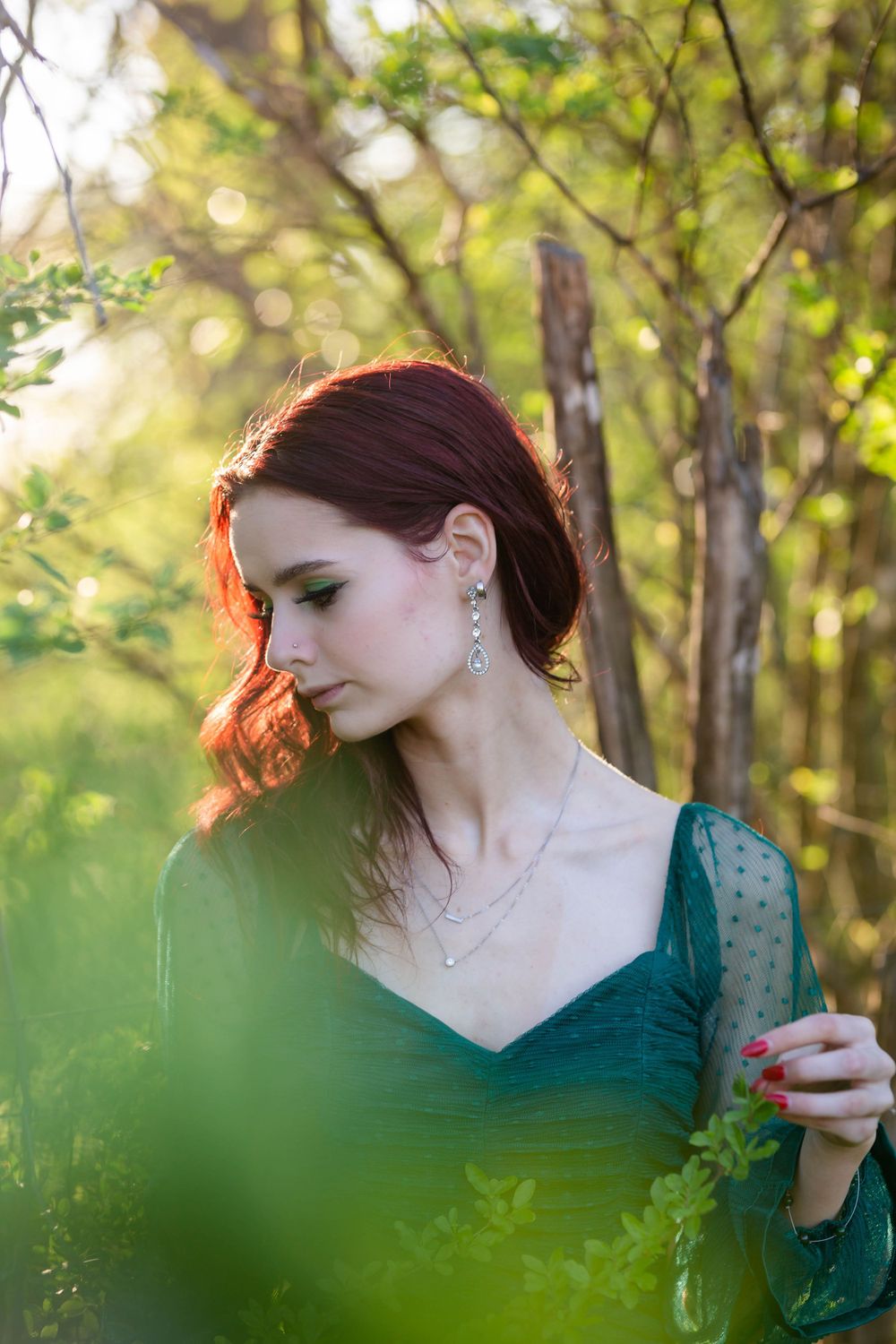 High school senior girl in a green dress among the trees during a senior session in Mountain Home, Arkansas