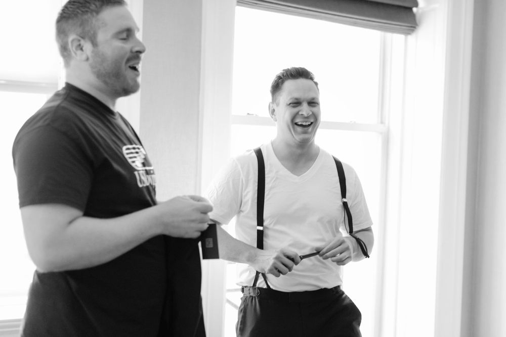 Two people engaged in cheerful conversation in a bright room, captured in black and white photography.