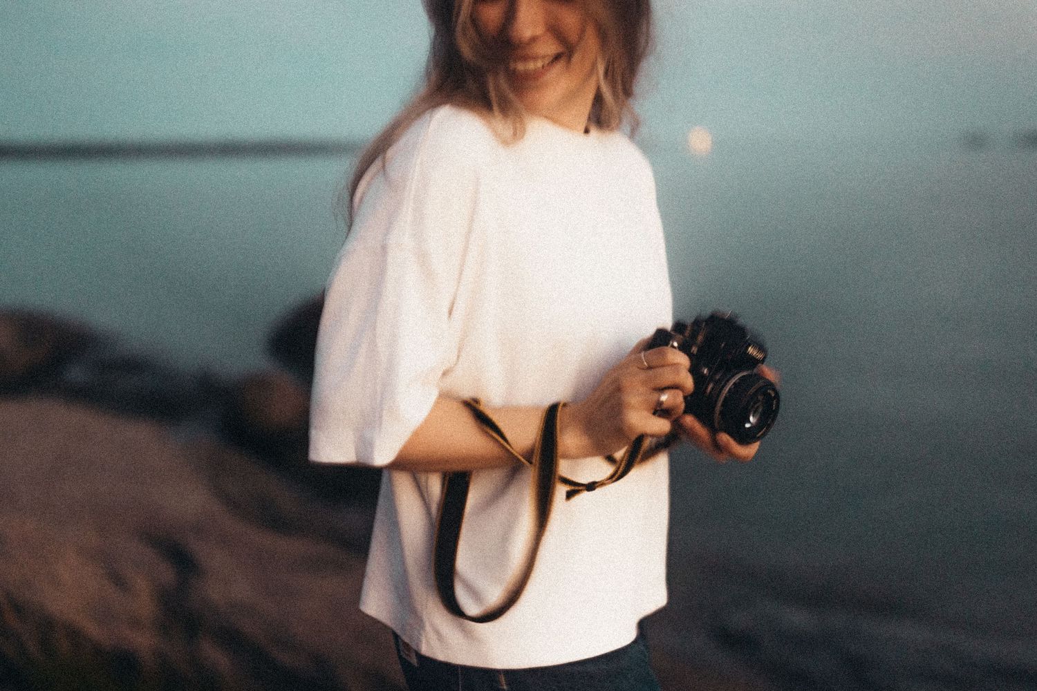 Wildflowers tucked into denim overalls pocket in a dreamy vintage photograph.