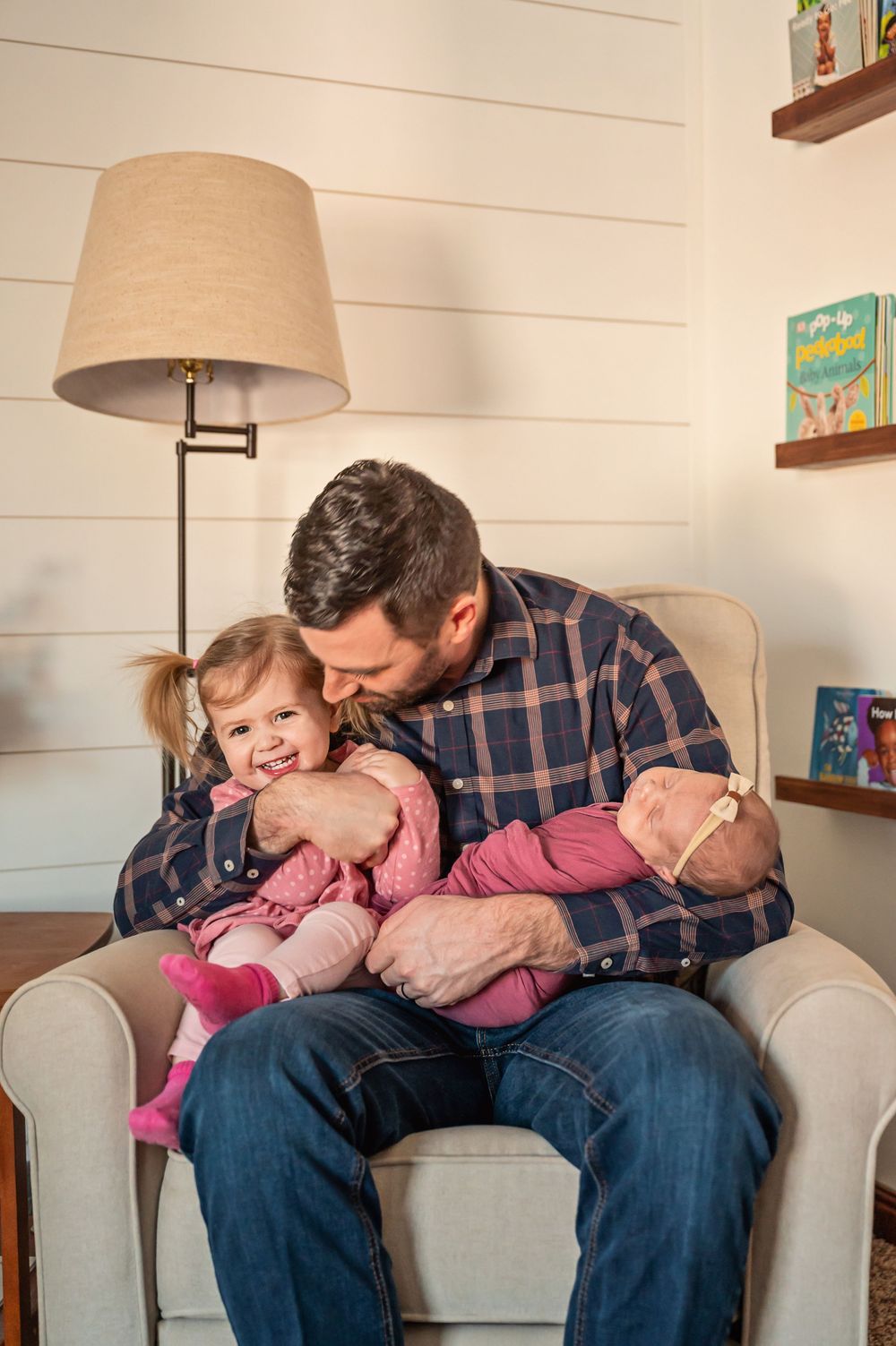 A series of tender moments showing someone cuddling a baby on a light gray couch in a cozy living room setting.