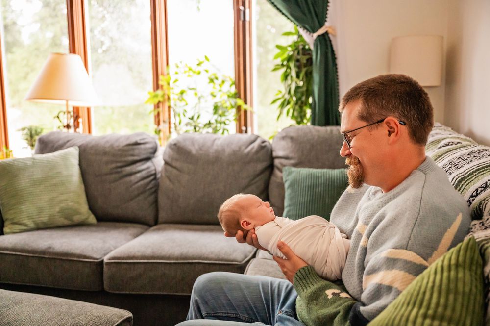 Five connected images show someone resting and reading on a gray couch with green throw pillows in a sunlit living room.