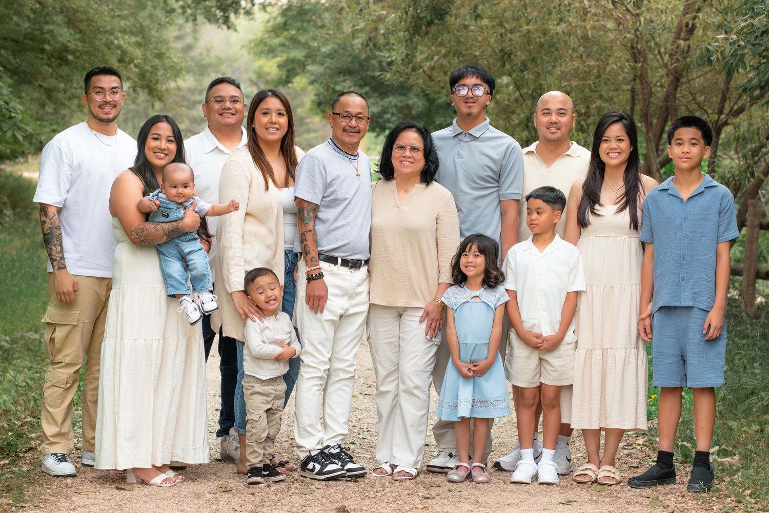 A coordinated family photo session outdoors with everyone wearing white, cream and light blue colored outfits.