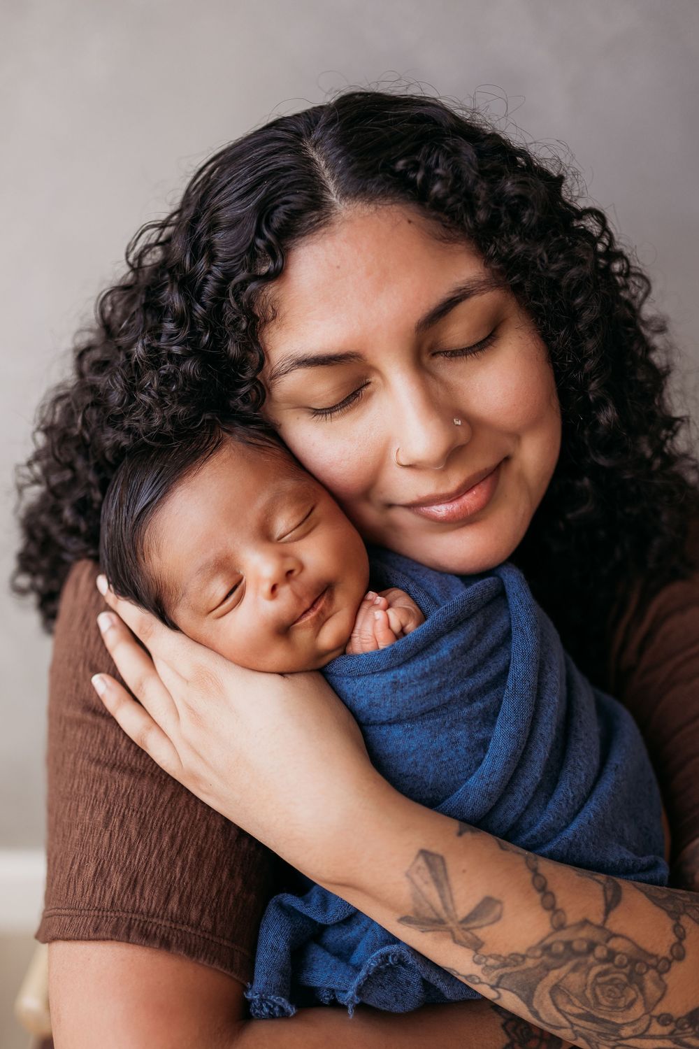 Mother holding newborn close to her face.