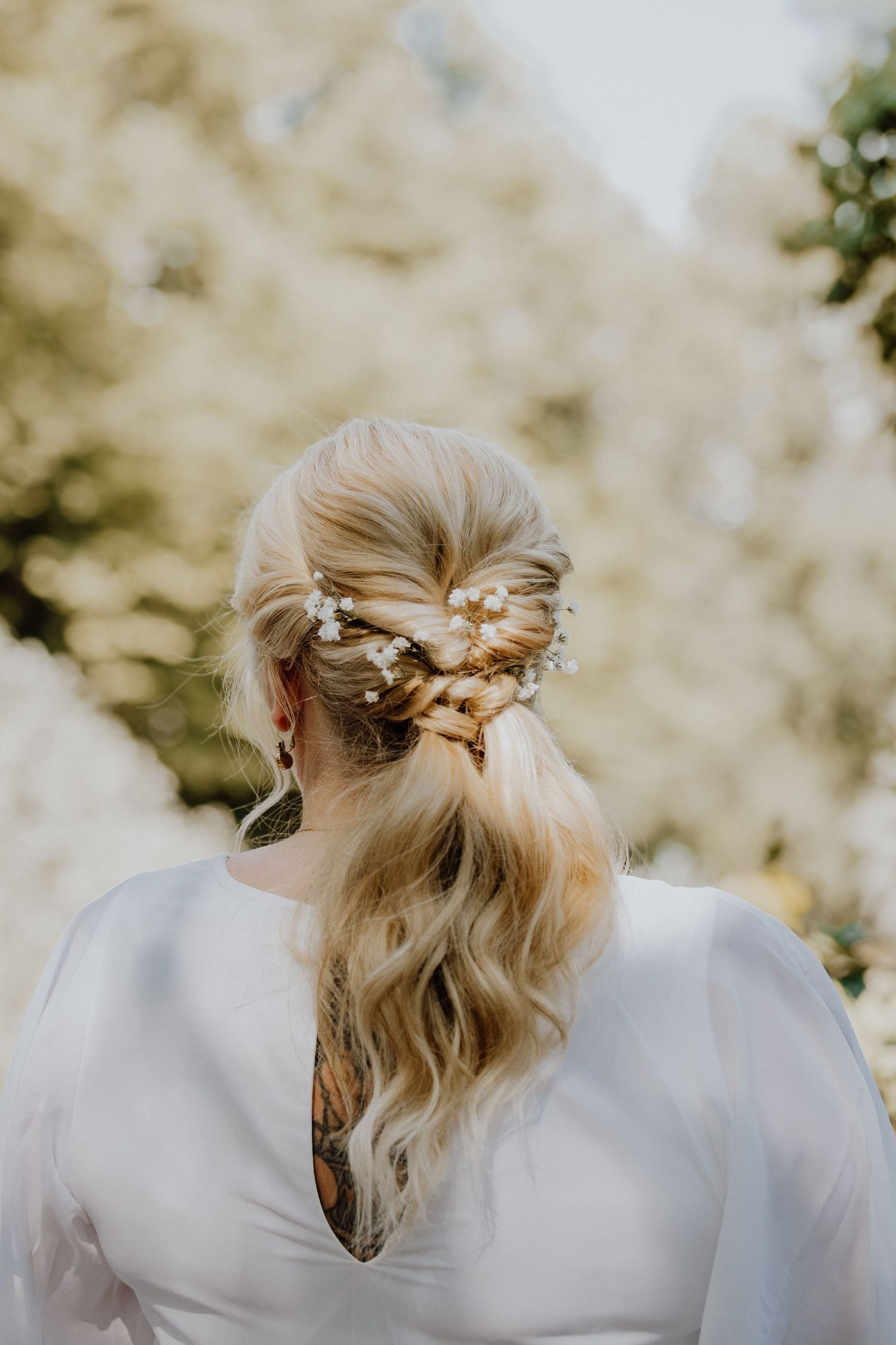 A series of four photos showing an elegant updo hairstyle with a delicate pearl hair accessory from different angles.