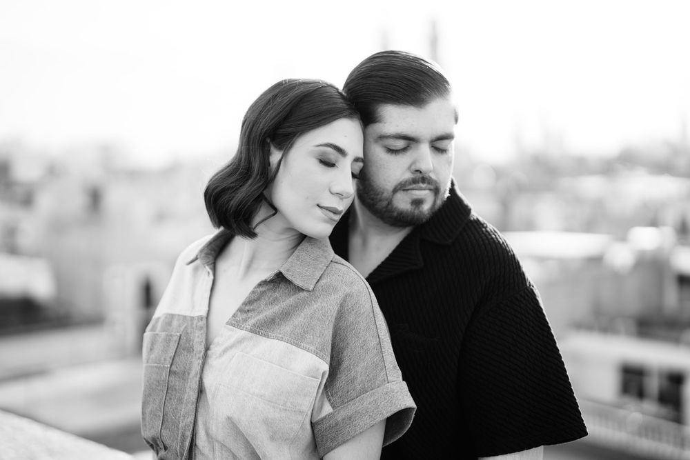 Romantic couple sharing intimate moments against an urban backdrop during a photo session.