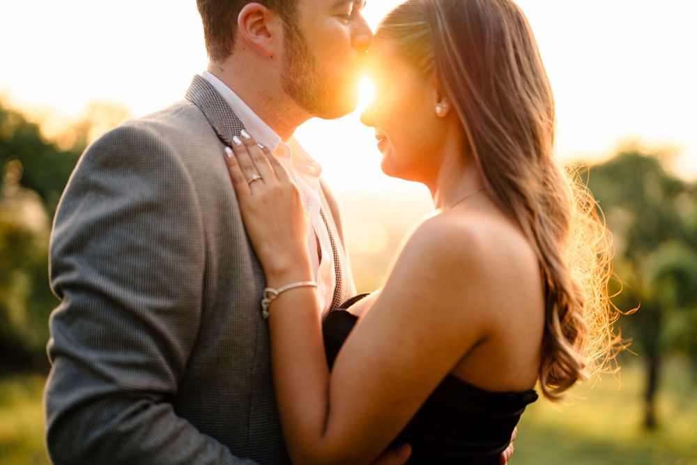 Romantic silhouettes of a couple in warm sunset lighting during an outdoor photoshoot.