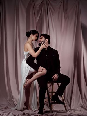 A romantic black and white photo series showing intimate poses between a couple against a light fabric backdrop.