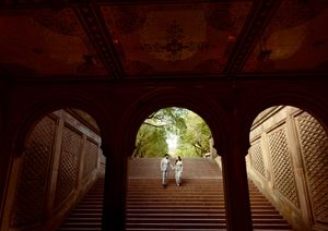 Symmetrical architectural view of stone arches and columns in a historic building with dramatic lighting.