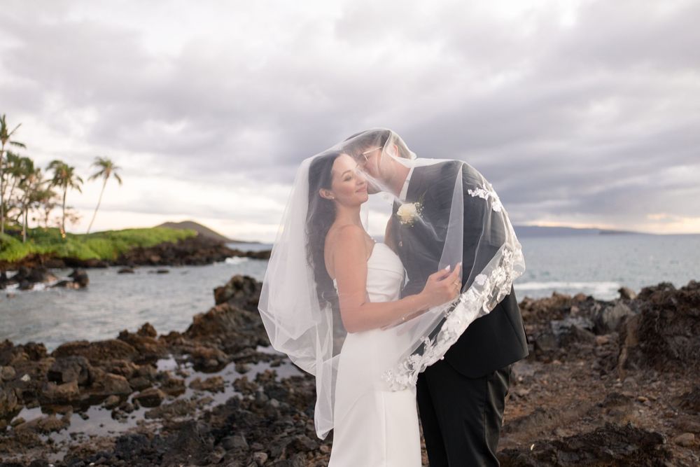 Intimate embrace between newlyweds during golden hour with sunlight streaming through trees.